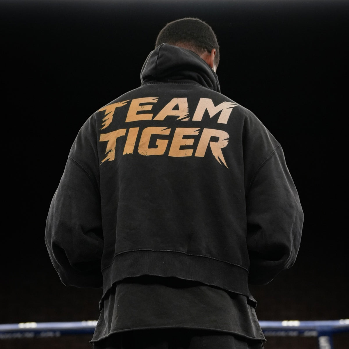 Back view of Tiger Johnson wearing black distressed oversized Tiger Johnson Supporter Hoodie