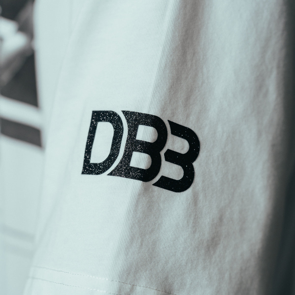 Close-up of DB3 logo on left sleeve of Keyshawn Davis "Evolution" Tee - Limited Edition